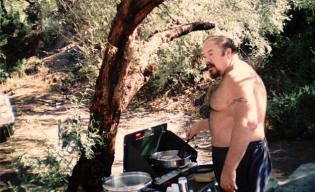 Paul cooks a gourmet camp meal.