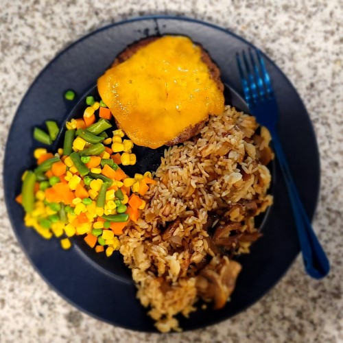 A cheeseburger, mixed vegetables, and a brown rice garlic sauteed mushroom medley.