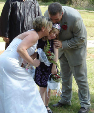 Cailey is kissed by her parents.