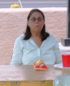 Mary enjoys her fun food at a table.