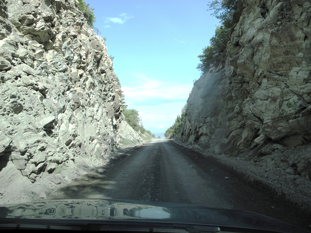 The gravel road led through a narrow cut in the rock.