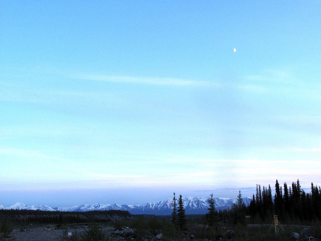 Moon over McCarthy, Alaska, in the summer midnight twilight.