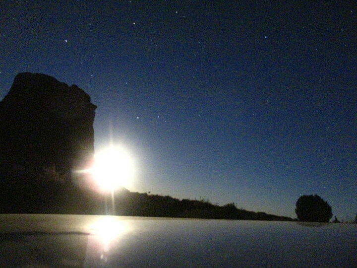 The moon reflected on the car hood.