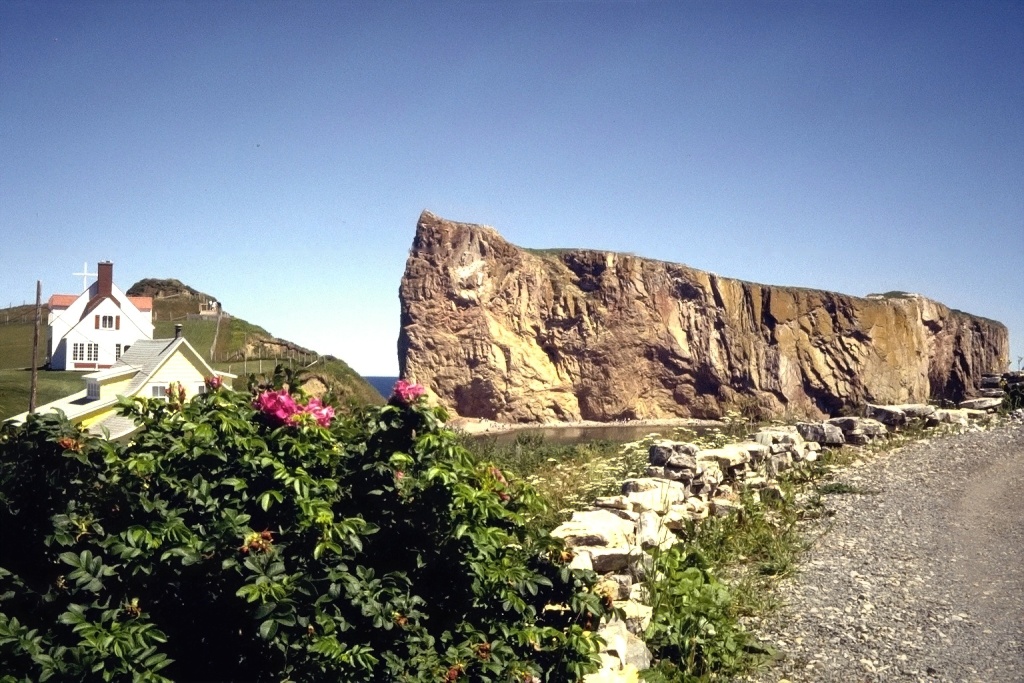 Perc&eacute; Rock, juxtaposed with a house and a parking lot.