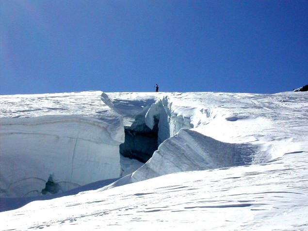 Climber crossing an ice bridge.